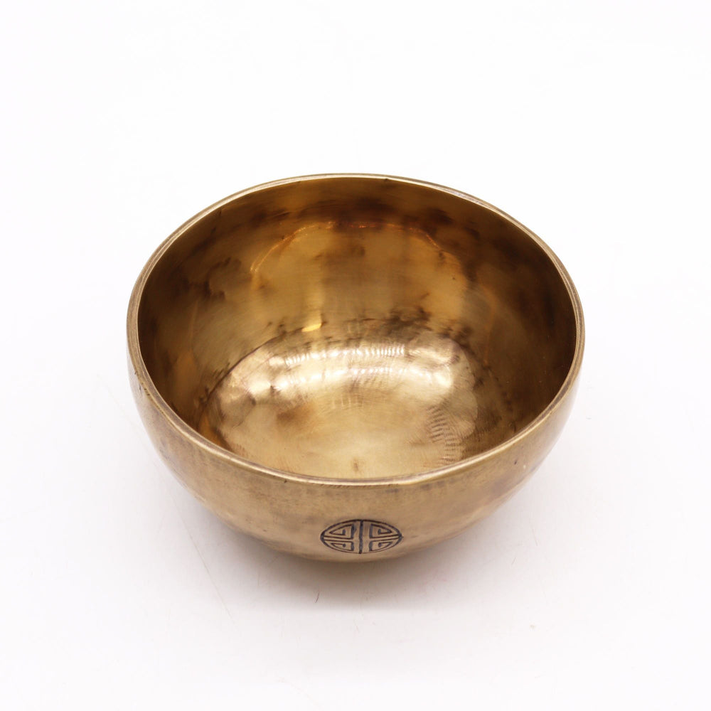 Gold singing bowl with a symbol on a white background