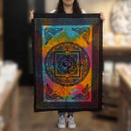 Person holding a colorful tapestry with a symbol design