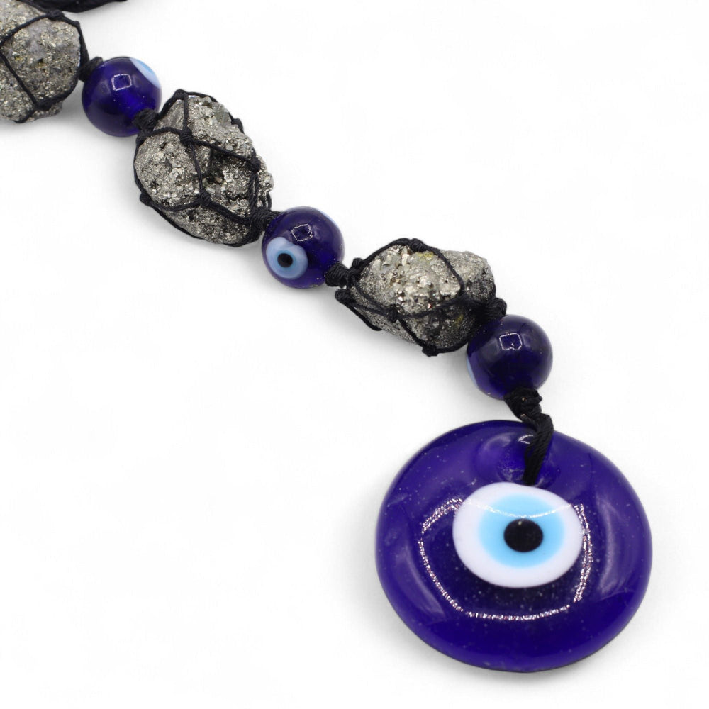 Necklace with blue evil eye pendant and black and gray beads on a white background