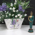 Floral arrangement with lavender and white tulips in a decorative pot, accompanied by a small Buddha statue.