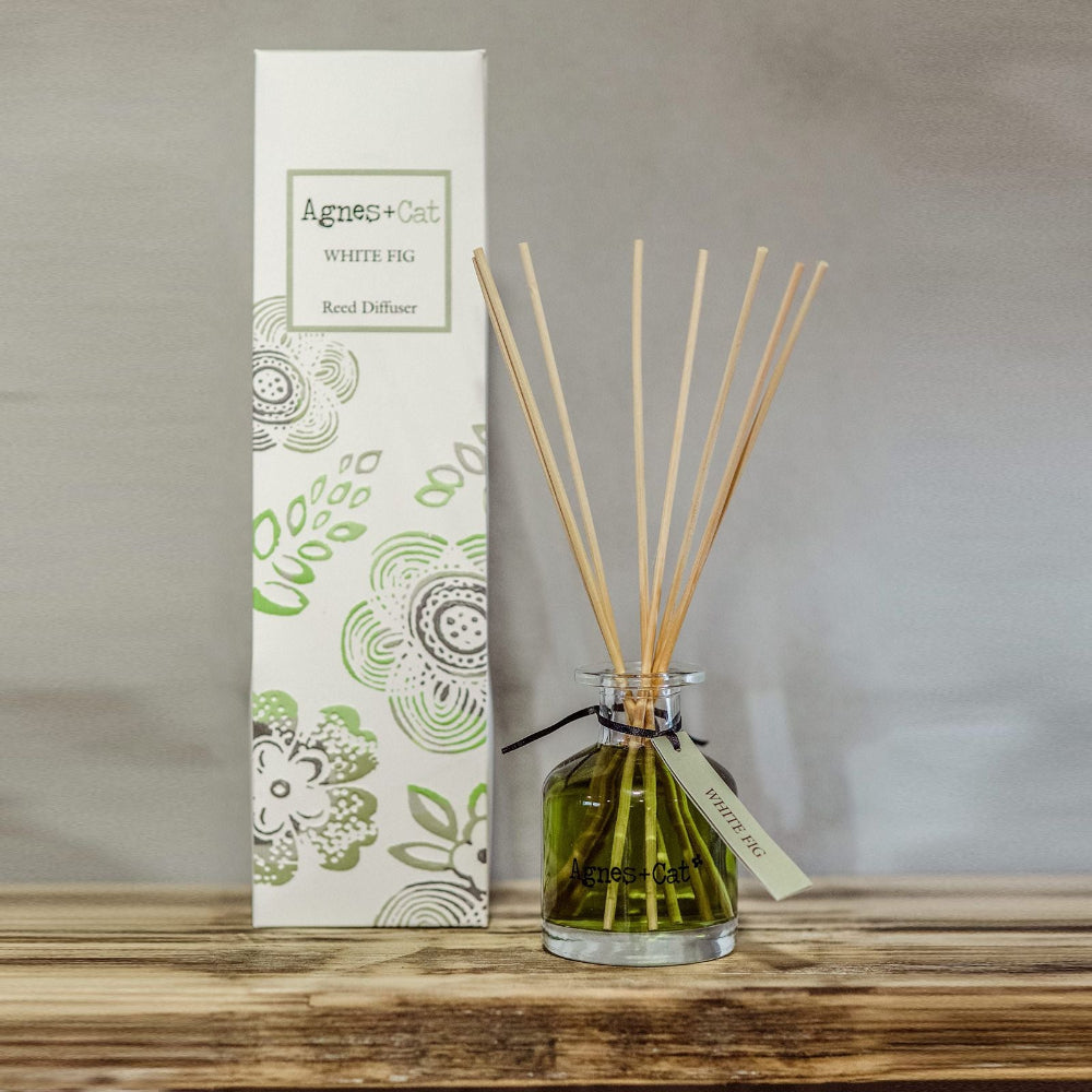 Aromatherapy diffuser with sticks and packaging on a wooden surface