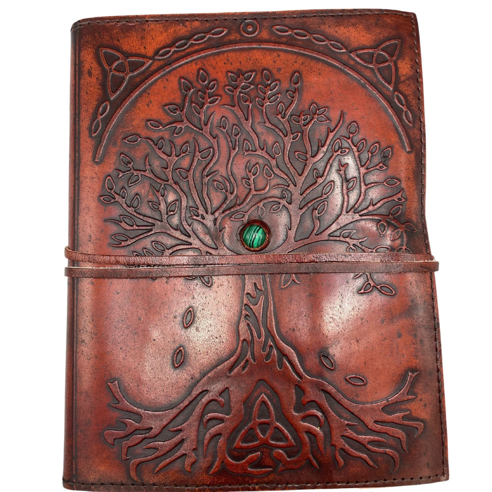 Brown leather journal with tree of life design and green gemstone on a white background
