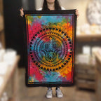 Person holding a colorful tapestry with a vibrant design