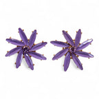Pair of purple star-shaped earrings on a white background