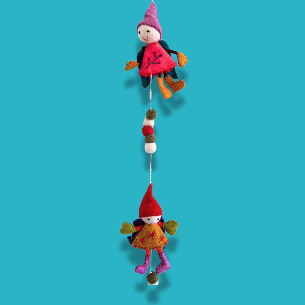 Two colorful gnome figurines hanging against a blue background