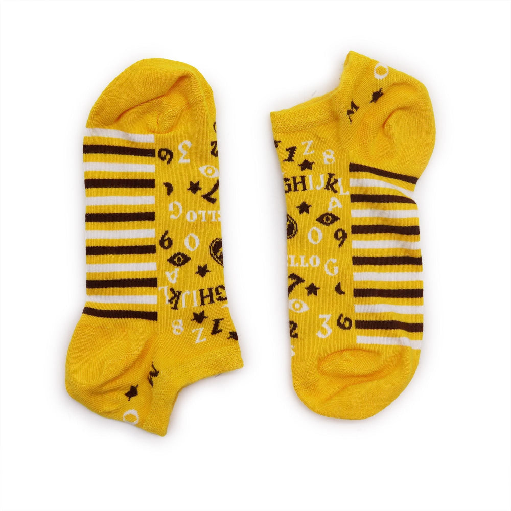 Pair of yellow socks with black and white patterns on a white background