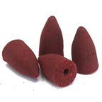 Four red conical incense cones on a white background
