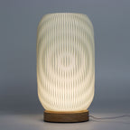 Textured table lamp with wooden base on a gray background