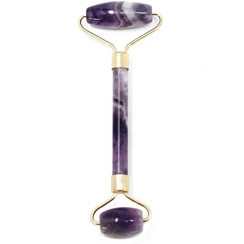 Purple jade roller with gold accents on a white background