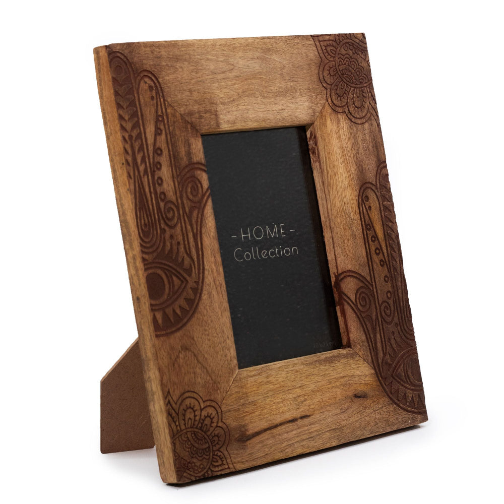 Wooden photo frame with intricate carvings on a white background