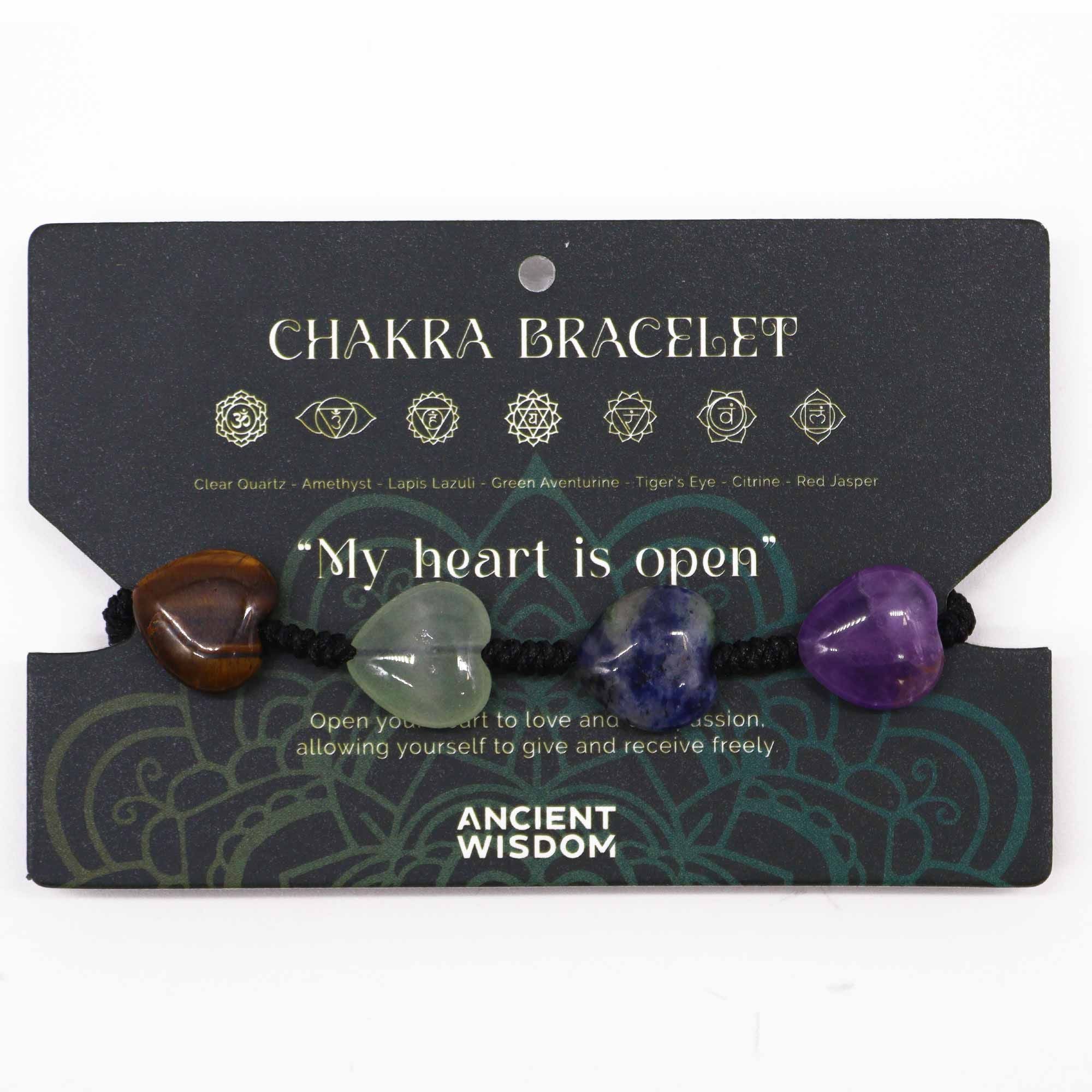 Chakra bracelet with heart-shaped stones on a black card with text and symbols.
