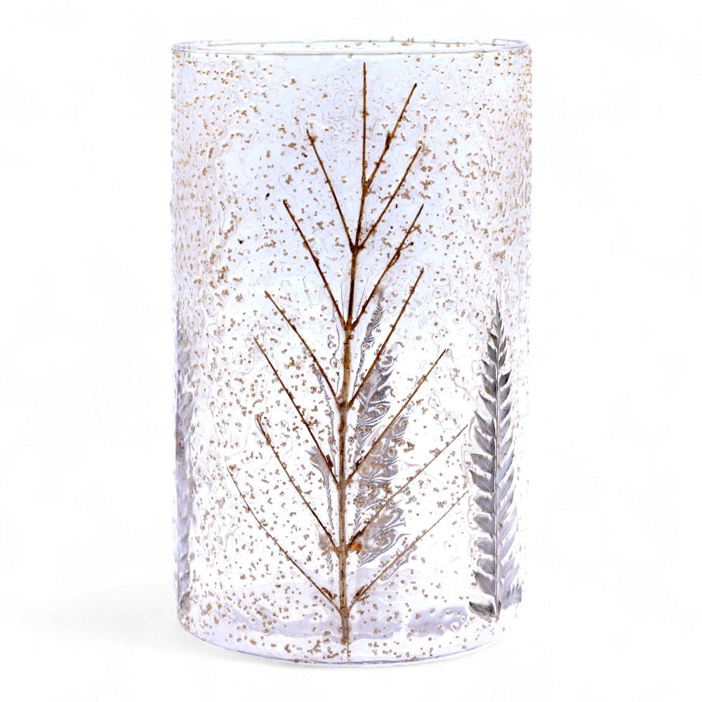 Clear glass candle holder with tree design and gold speckles on a white background