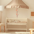 Nursery room with a crib, canopy, and decorative elements.