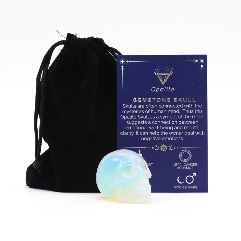 Opalite gemstone skull with black drawstring bag and information card on a white background