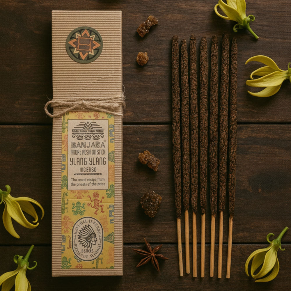 Bottle of Banjara Ylang Ylang incense sticks on a wooden surface with flowers and spices.