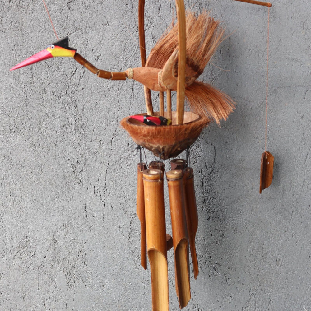 Wooden wind chime shaped like a toucan against a gray wall