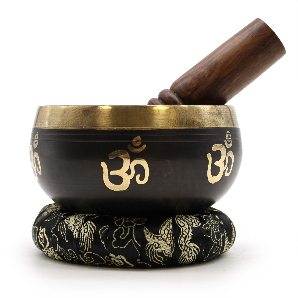 Tibetan singing bowl with wooden striker on a white background