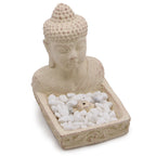 Buddha head sculpture with pebbles on a white background