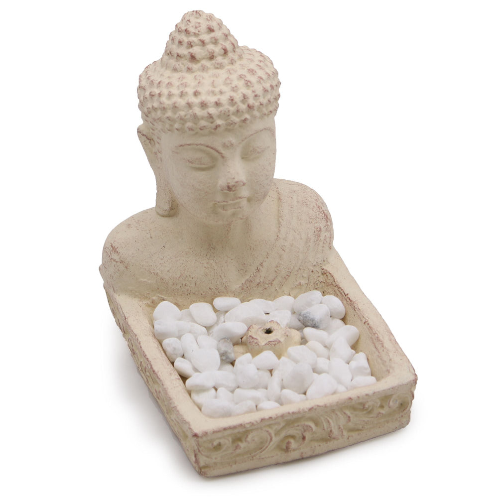 Buddha head sculpture with pebbles on a white background