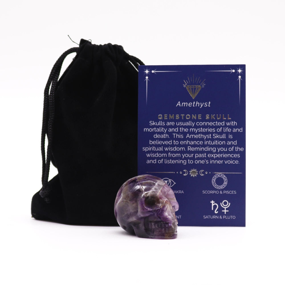 Amethyst crystal skull with black drawstring bag and information card on a white background