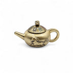 Brass teapot with decorative elements on a white background