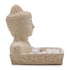 Stone sculpture of a Buddha head with a decorative base on a white background