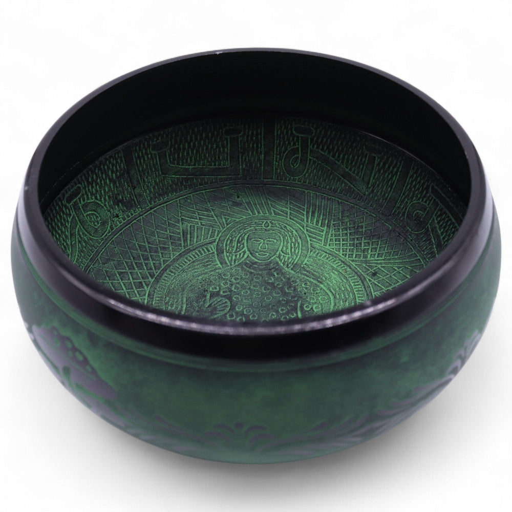 Green singing bowl with intricate patterns on a white background