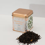 Tea tin labeled 'Mandala Leaves' with loose tea leaves on a white background