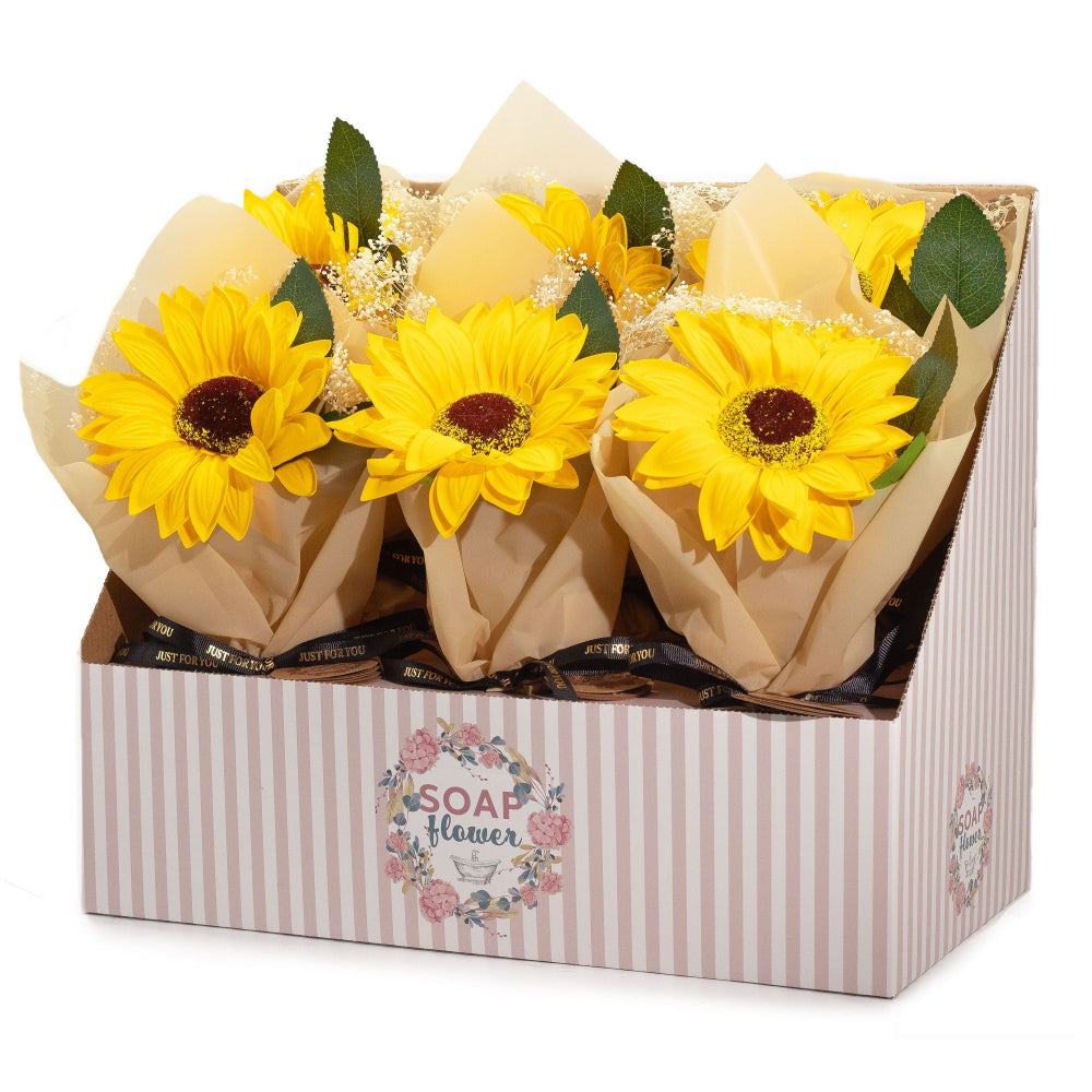 Bouquets of yellow sunflowers in brown paper packaging inside a decorative box with 'SOAP & FLORAL' branding.