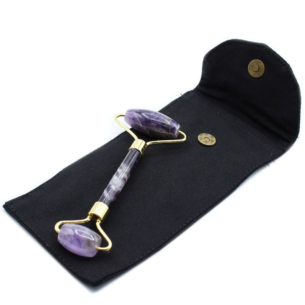 Amethyst facial roller on a black pouch with gold accents