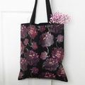 Black tote bag with purple floral pattern on a white background