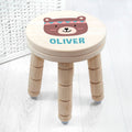 Wooden stool with a bear face design and 'OLIVER' text on a white background