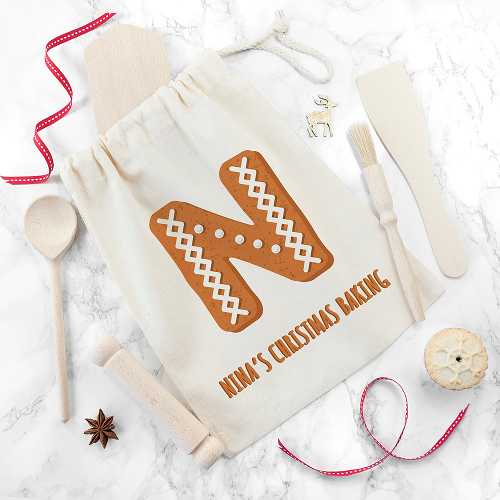 Baking-themed drawstring bag with gingerbread design and text, surrounded by baking tools on a marble surface.
